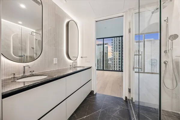 a bathroom with double vanity and a mirror
