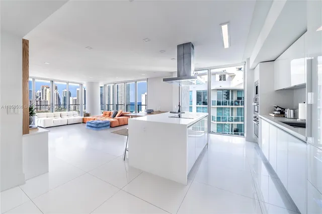 a large white kitchen with a lot of counter space and a sink