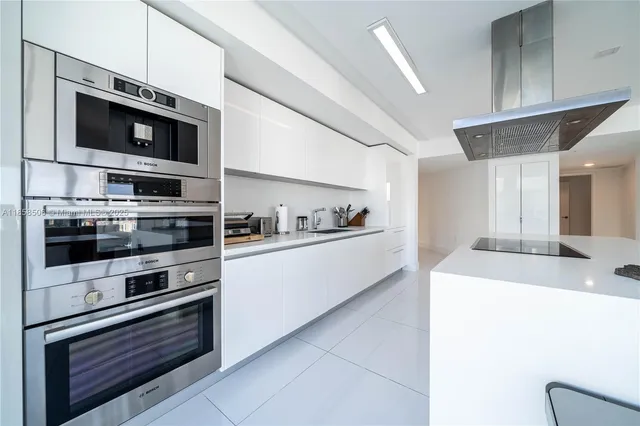 a kitchen with stainless steel appliances and view of living room