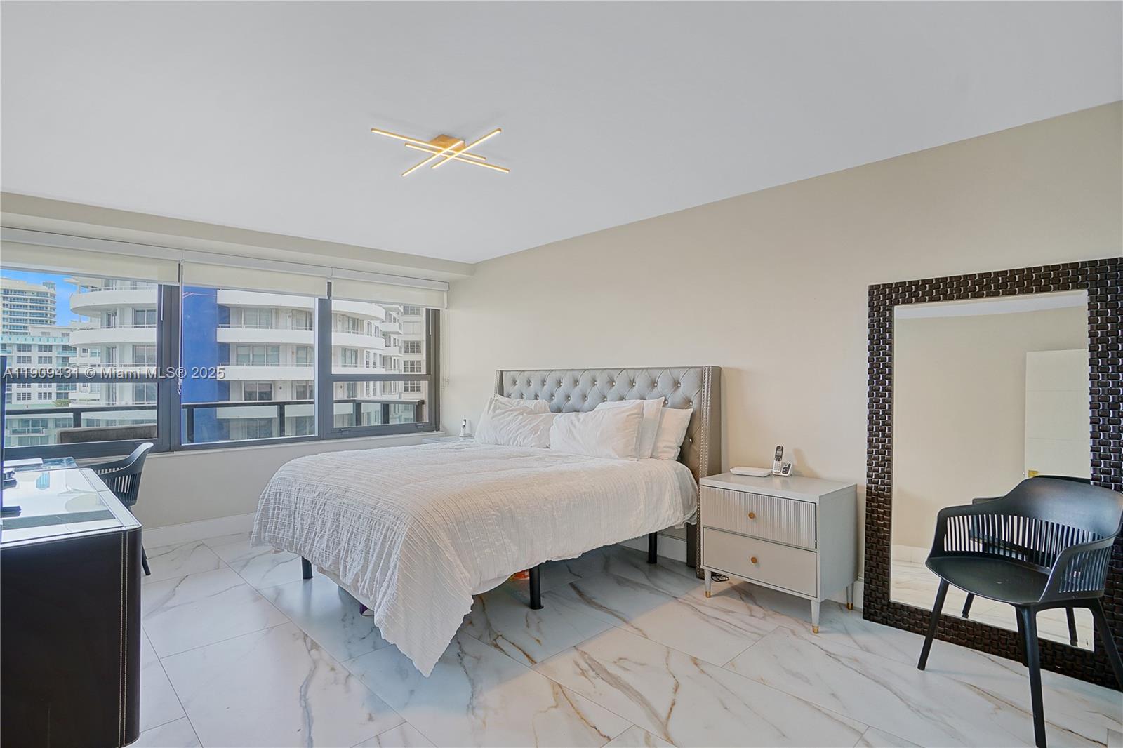 5225 Collins Avenue, Unit 1403 Miami Beach, FL 33140 - Photo 11 of 21 a bedroom with a bed and a large window