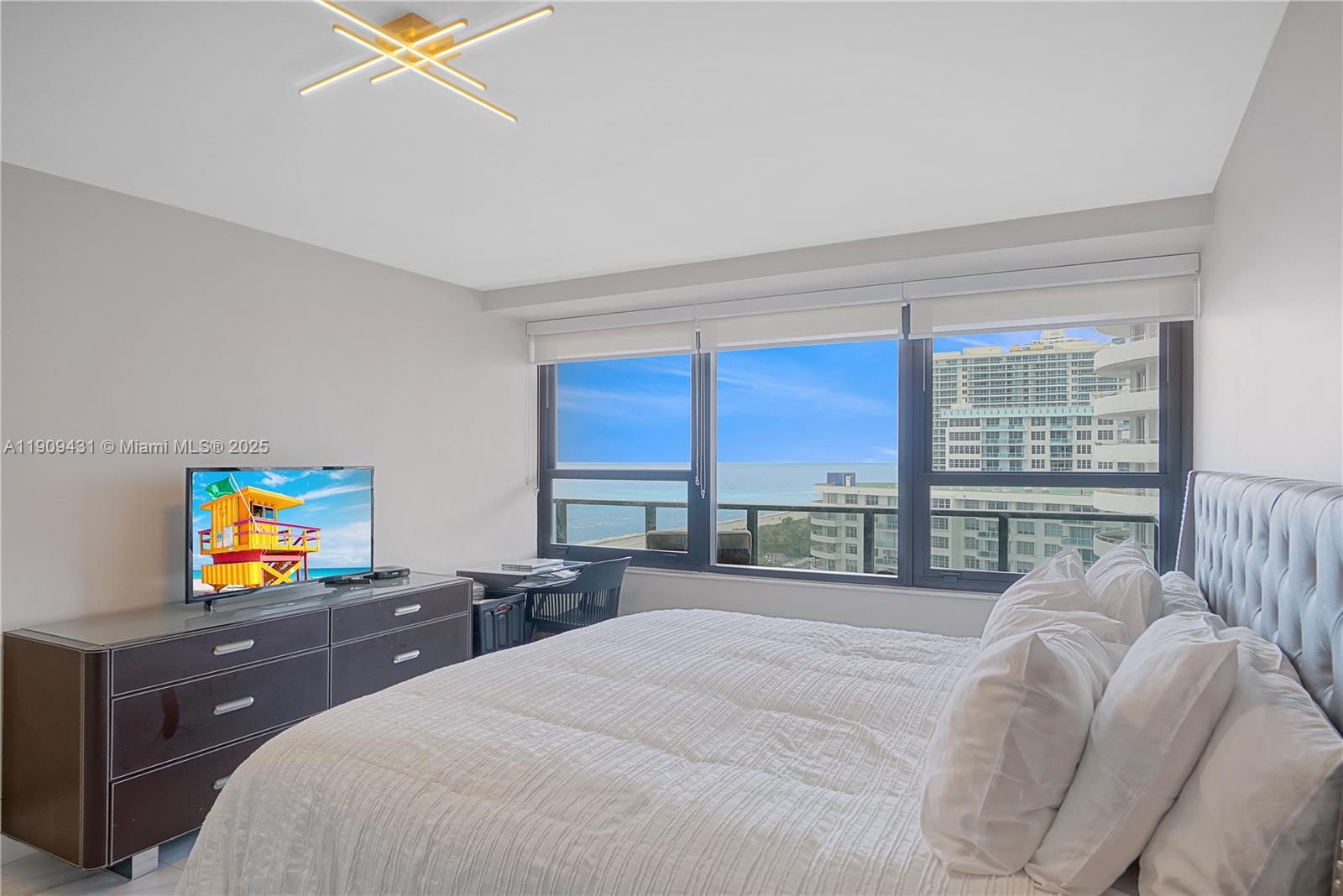 5225 Collins Avenue, Unit 1403 Miami Beach, FL 33140 - Photo 12 of 21 a bedroom with a bed and a flat screen tv