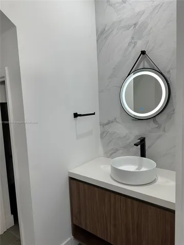 a large kitchen with stainless steel appliances a sink and a refrigerator