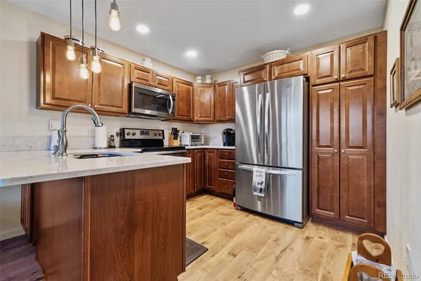 a kitchen with stainless steel appliances granite countertop a refrigerator stove and sink