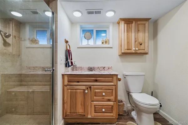 a bathroom with a toilet a sink and mirror