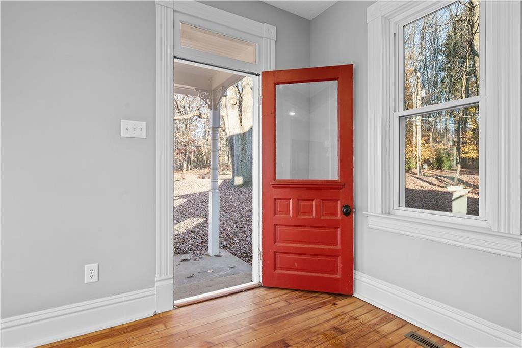 151 Rockdale Road Butler, PA 16002 - Photo 3 of 25 an empty room with wooden floor mirror and windows