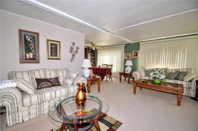 a living room with furniture kitchen view and a window