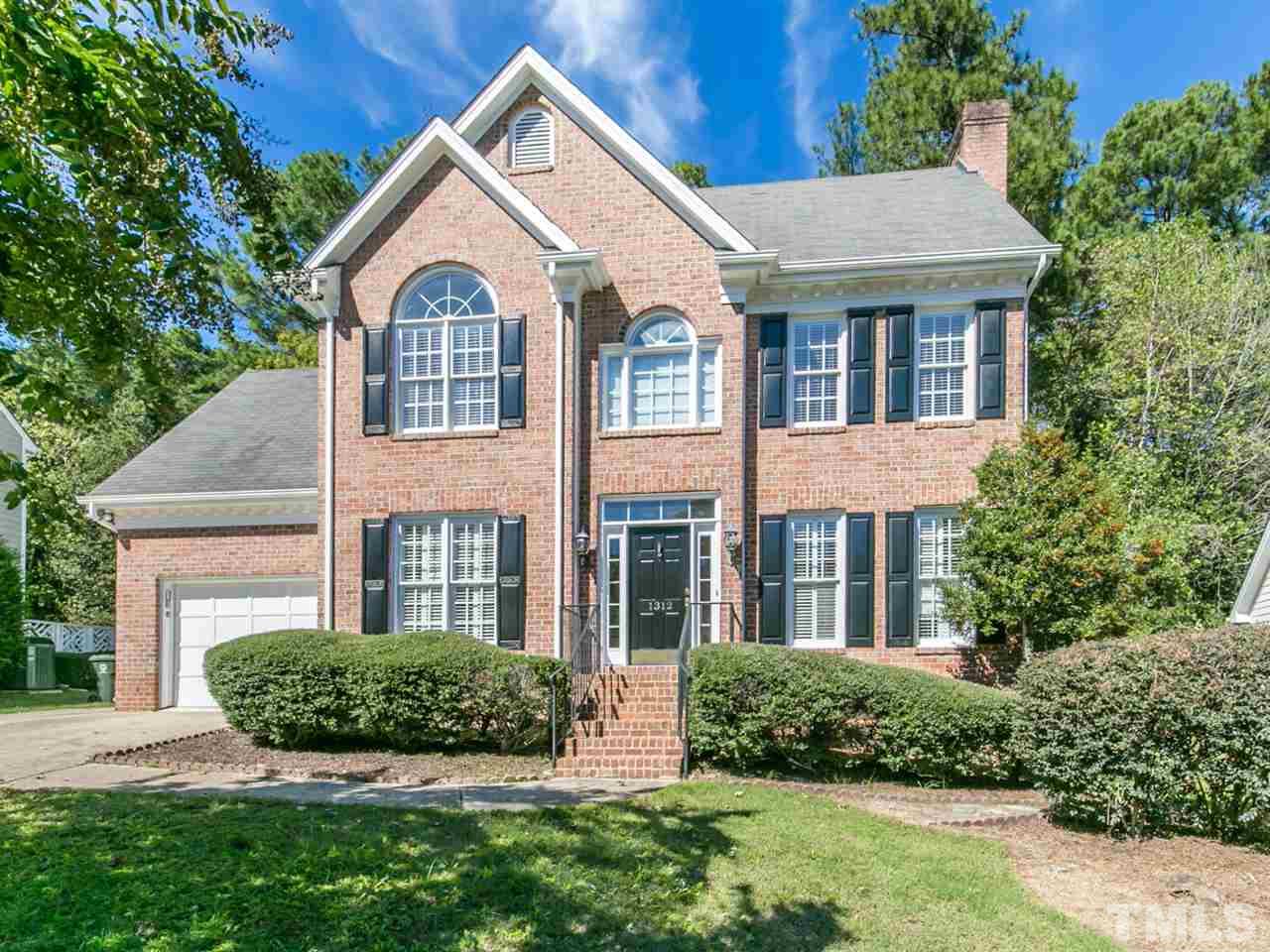 a view of a brick house with a yard