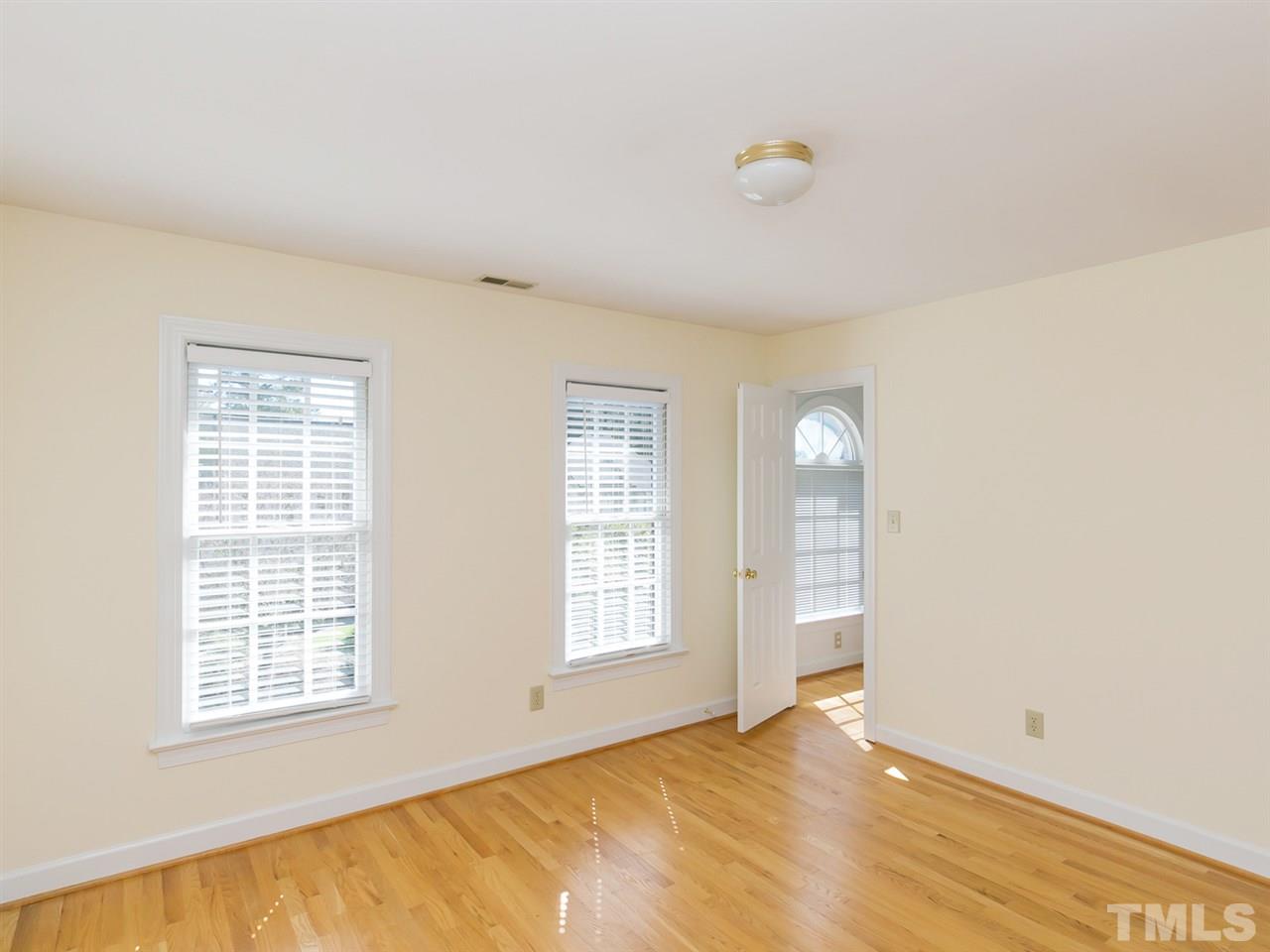 1312 Binley Place Raleigh, NC 27615 - Photo 14 of 22 a view of an empty room with wooden floor and a window