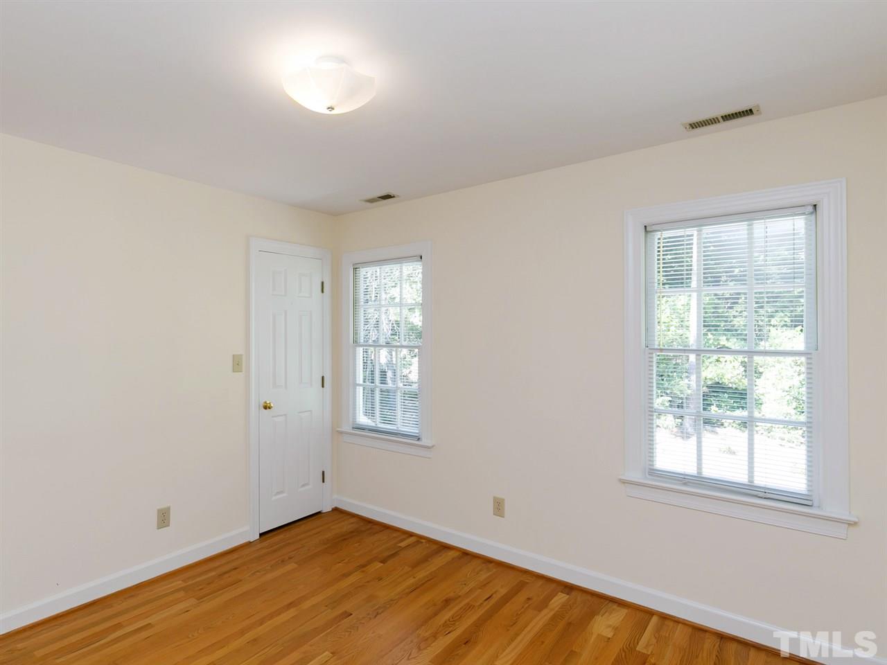 1312 Binley Place Raleigh, NC 27615 - Photo 15 of 22 an empty room with wooden floor and windows