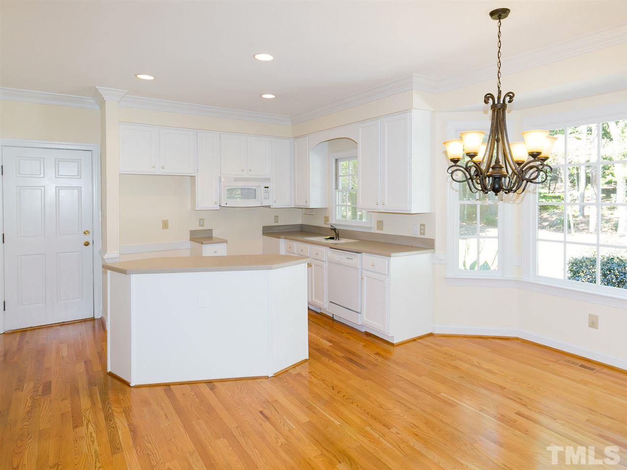 1312 Binley Place Raleigh, NC 27615 - Photo 4 of 22 a living room with stainless steel appliances kitchen island granite countertop a sink a window and white cabinets