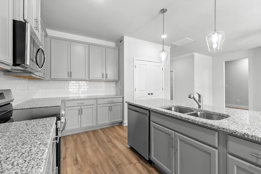 154 Greenview Court Homer, GA 30547 - Photo 14 of 44 a kitchen with stainless steel appliances granite countertop a sink a stove a oven a refrigerator with white cabinets and wooden floor
