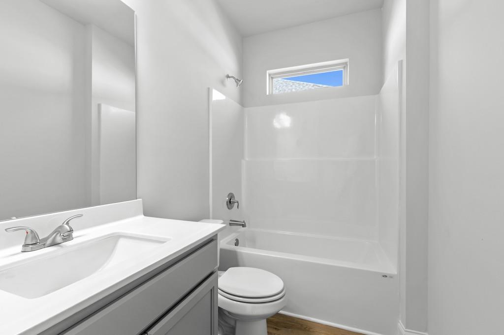 154 Greenview Court Homer, GA 30547 - Photo 19 of 44 a bathroom with a granite countertop toilet a sink and a mirror