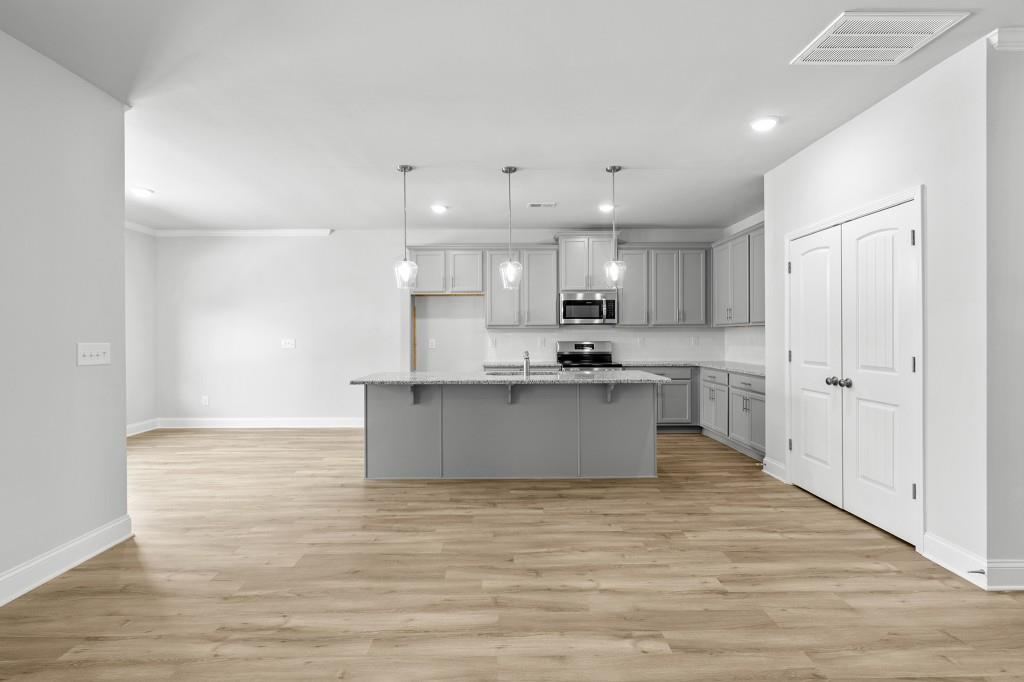 154 Greenview Court Homer, GA 30547 - Photo 9 of 44 a large kitchen with stainless steel appliances kitchen island a large counter top and a wooden floors