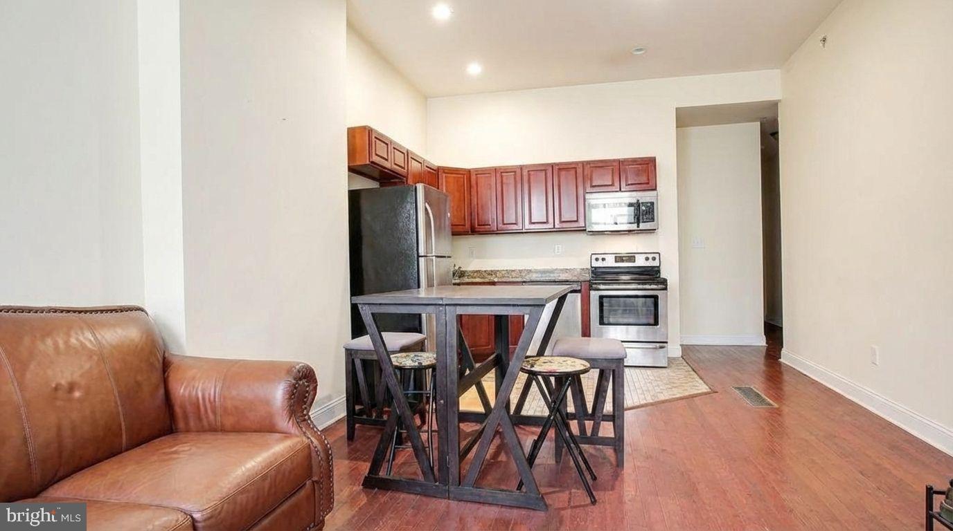 a kitchen with stainless steel appliances kitchen island granite countertop a refrigerator and microwave