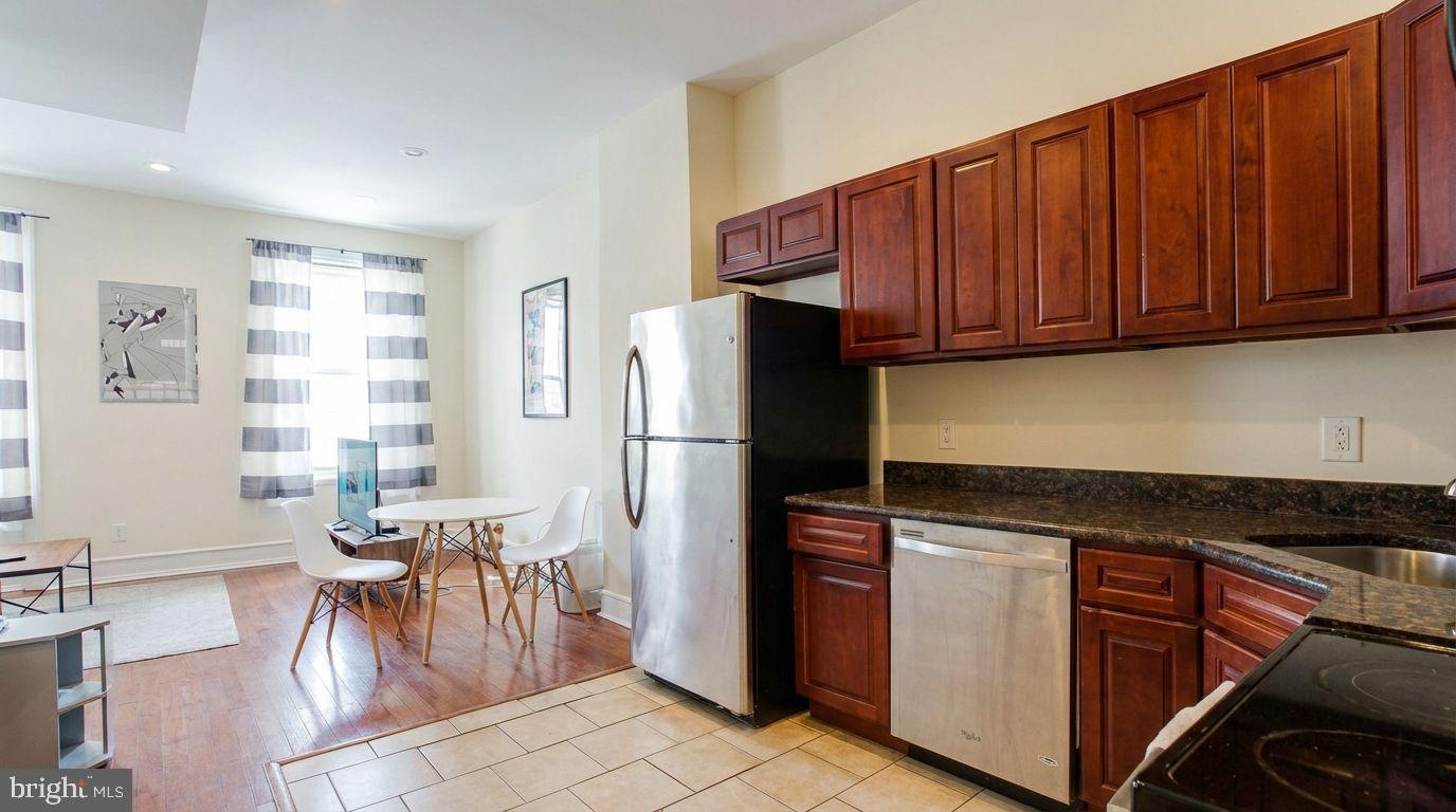 1920 North 18th Street, Unit 1 Philadelphia, PA 19121 - Photo 2 of 12 a kitchen with stainless steel appliances granite countertop a refrigerator and a stove top oven