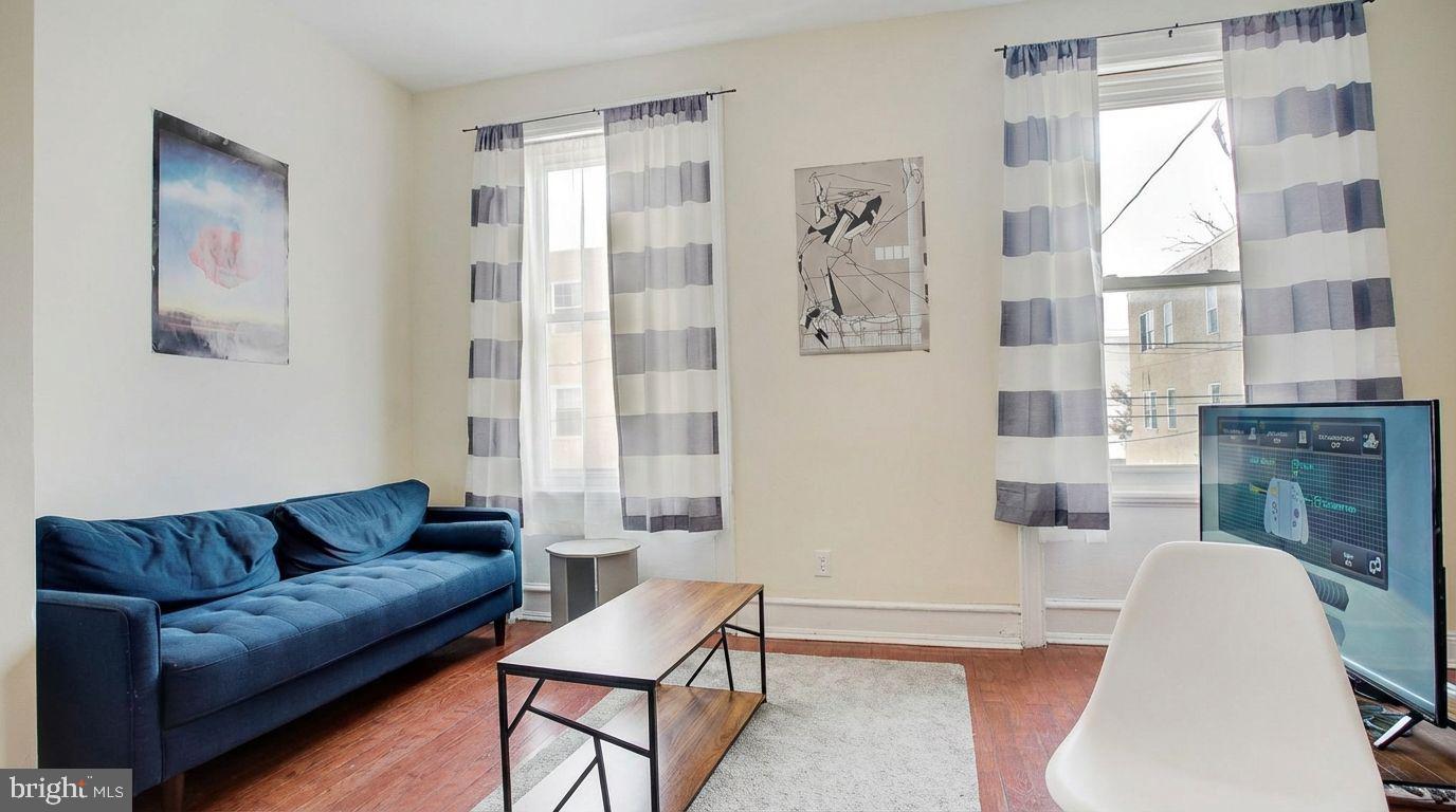 1920 North 18th Street, Unit 1 Philadelphia, PA 19121 - Photo 4 of 12 a living room with furniture a fireplace and a large window