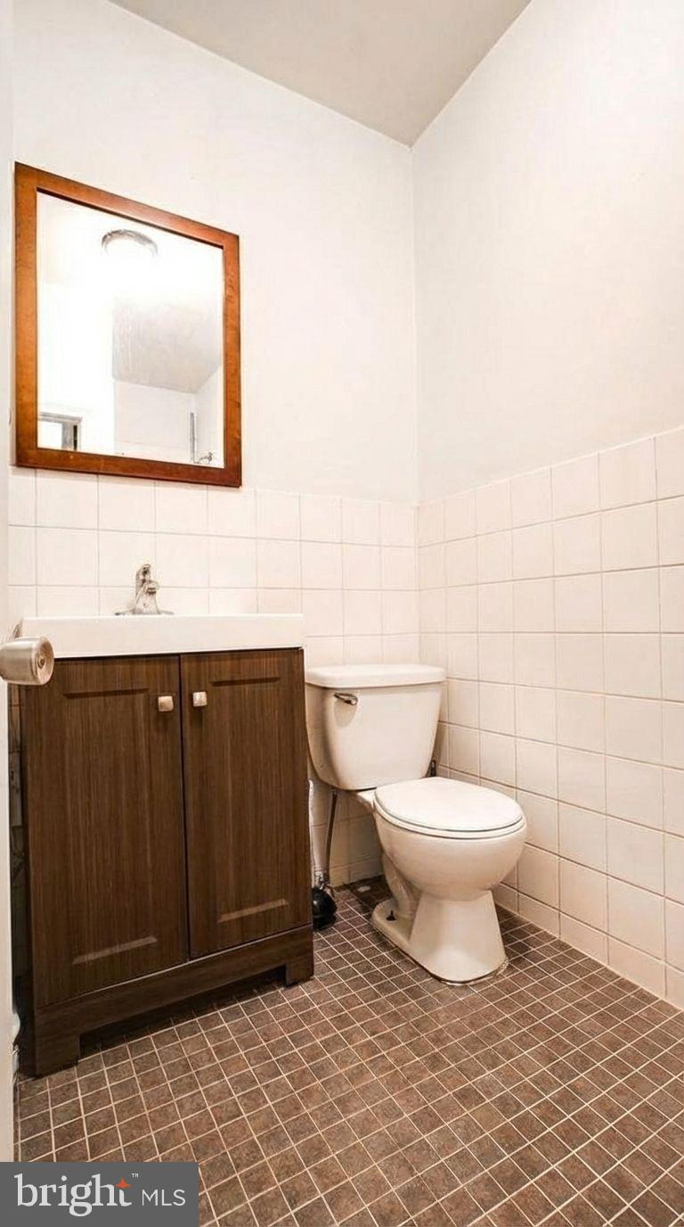 1920 North 18th Street, Unit 1 Philadelphia, PA 19121 - Photo 8 of 12 a bathroom with a toilet a sink and mirror