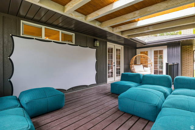 4150 Dover Lane Provo, UT 84604 - Photo 34 of 44 Covered outdoor patio featuring a large projection screen, two sets of French doors, wood-finish decking, and an exposed beam ceiling