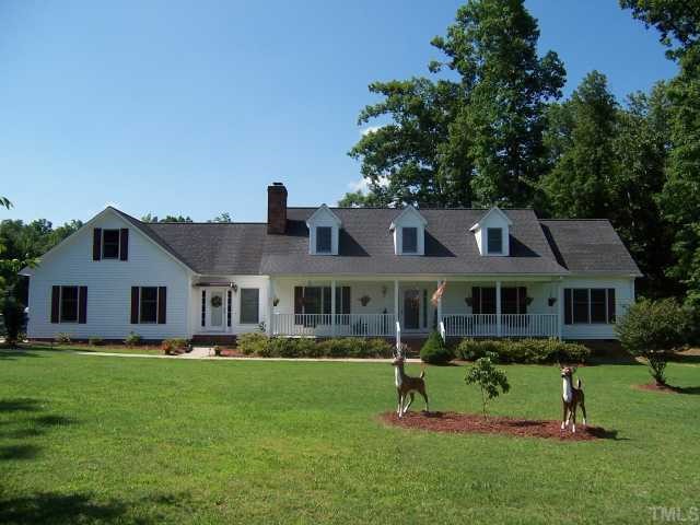 2431 Flat River Church Road Roxboro, NC 27574 - Photo 1 of 12 a front view of a house with a garden and trees