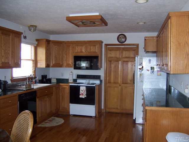 2431 Flat River Church Road Roxboro, NC 27574 - Photo 5 of 12 a kitchen with stainless steel appliances granite countertop a refrigerator a stove top oven a sink and dishwasher