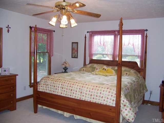 2431 Flat River Church Road Roxboro, NC 27574 - Photo 9 of 12 a bedroom with a bed and a chandelier