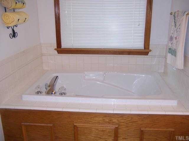 2431 Flat River Church Road Roxboro, NC 27574 - Photo 10 of 12 a bathroom with a bathtub and a window