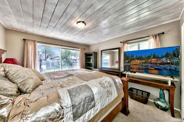 a bedroom with a bed and large windows