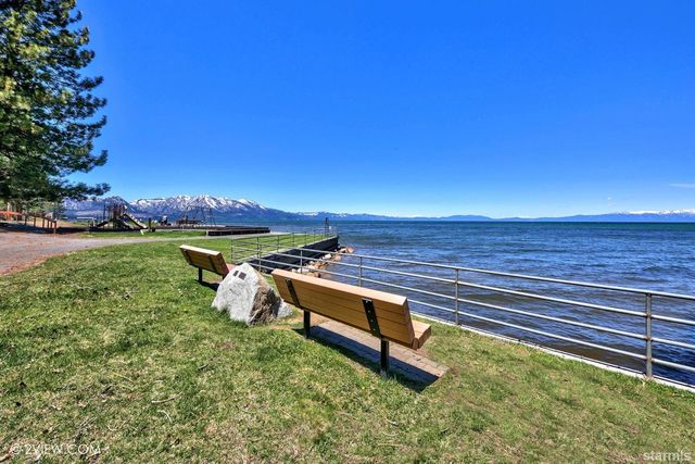 a view of a bench in the garden near a lake