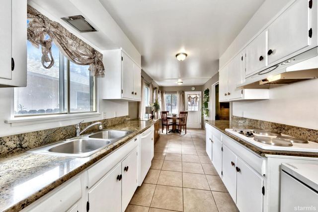 a kitchen with stainless steel appliances granite countertop a sink stove and cabinets