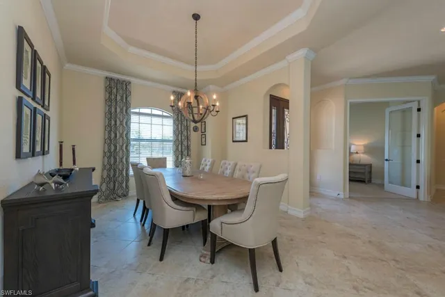 a dining room with furniture a chandelier and wooden floor