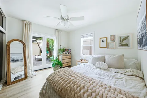 a bedroom with a bed and a large mirror next to a window