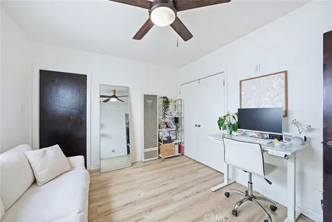 a workspace with a couch and a ceiling fan