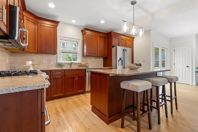 a kitchen with granite countertop a sink stove and refrigerator