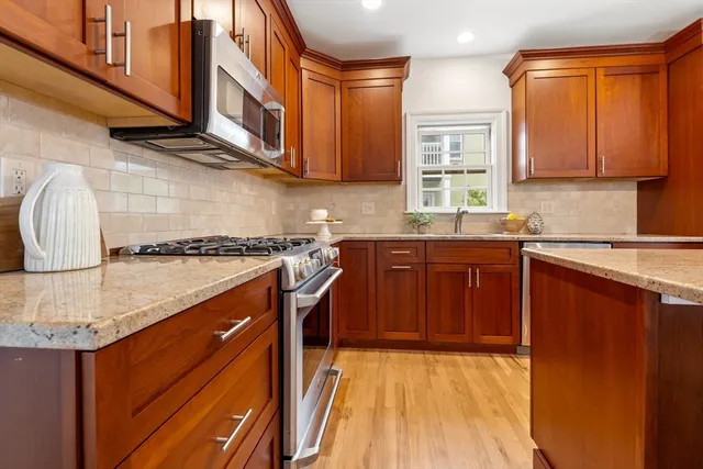 a kitchen with stainless steel appliances granite countertop a sink stove and cabinets
