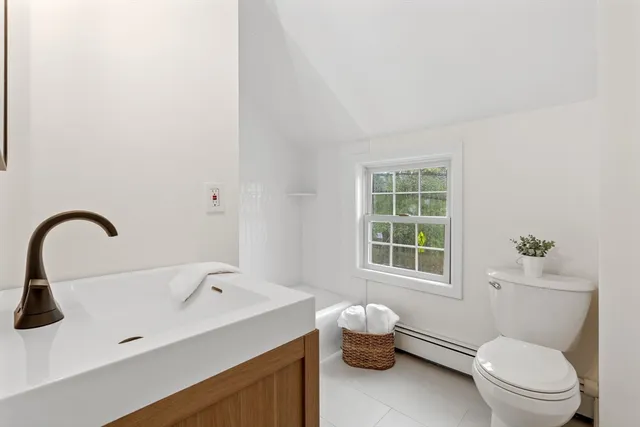 a bathroom with a sink toilet and a window