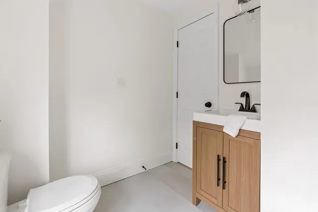 a bathroom with a sink a toilet and mirror