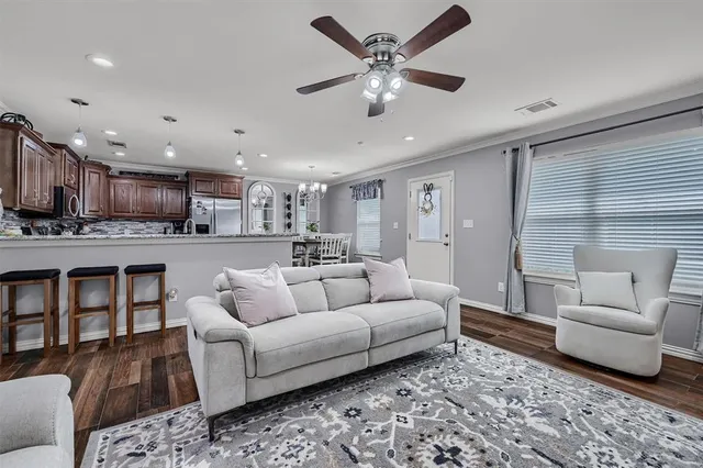 a living room with furniture and a view of kitchen