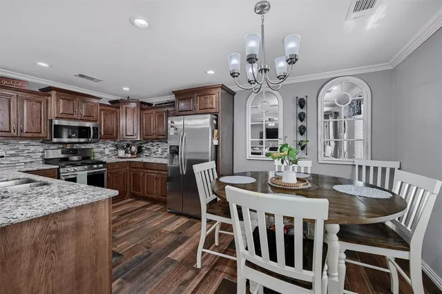 a view of a dining room with furniture a chandelier and wooden floor
