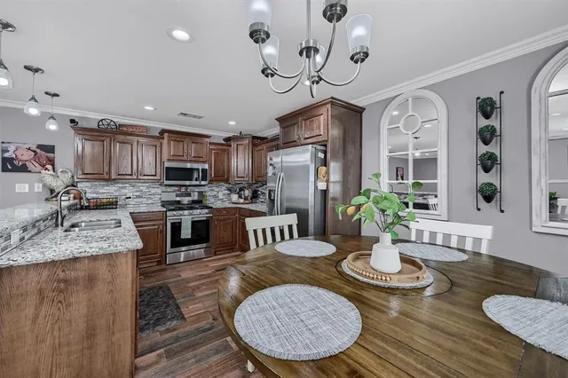 a kitchen with sink refrigerator dining table and chairs