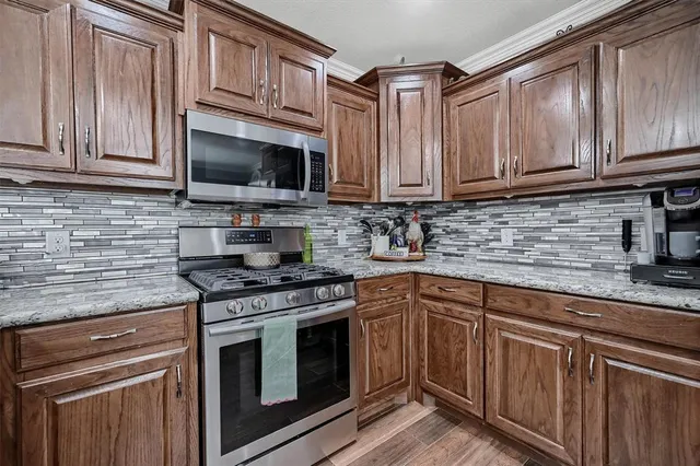 a kitchen with stainless steel appliances granite countertop a sink stove and microwave