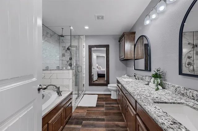 a spacious bathroom with a granite countertop sink mirror and shower