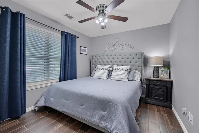 a bedroom with a bed and a table with wooden floor