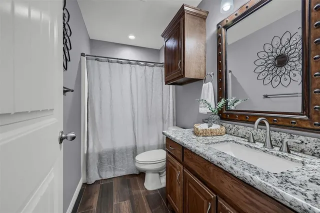 a bathroom with a granite countertop sink toilet and shower