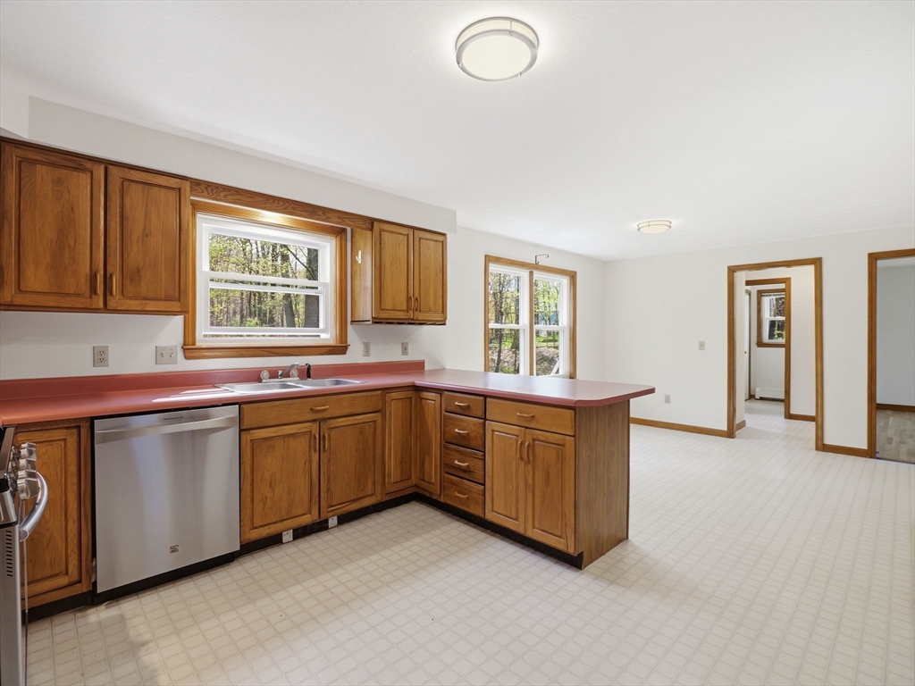 26 Nevada Road Tyngsborough, MA 01879 - Photo 11 of 42 a large kitchen with granite countertop a sink dishwasher a stove and a refrigerator with wooden floor