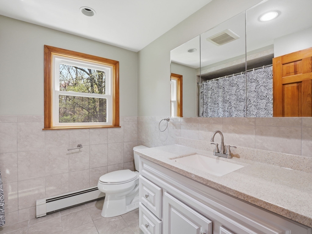 26 Nevada Road Tyngsborough, MA 01879 - Photo 30 of 42 a bathroom with a sink a toilet and mirror