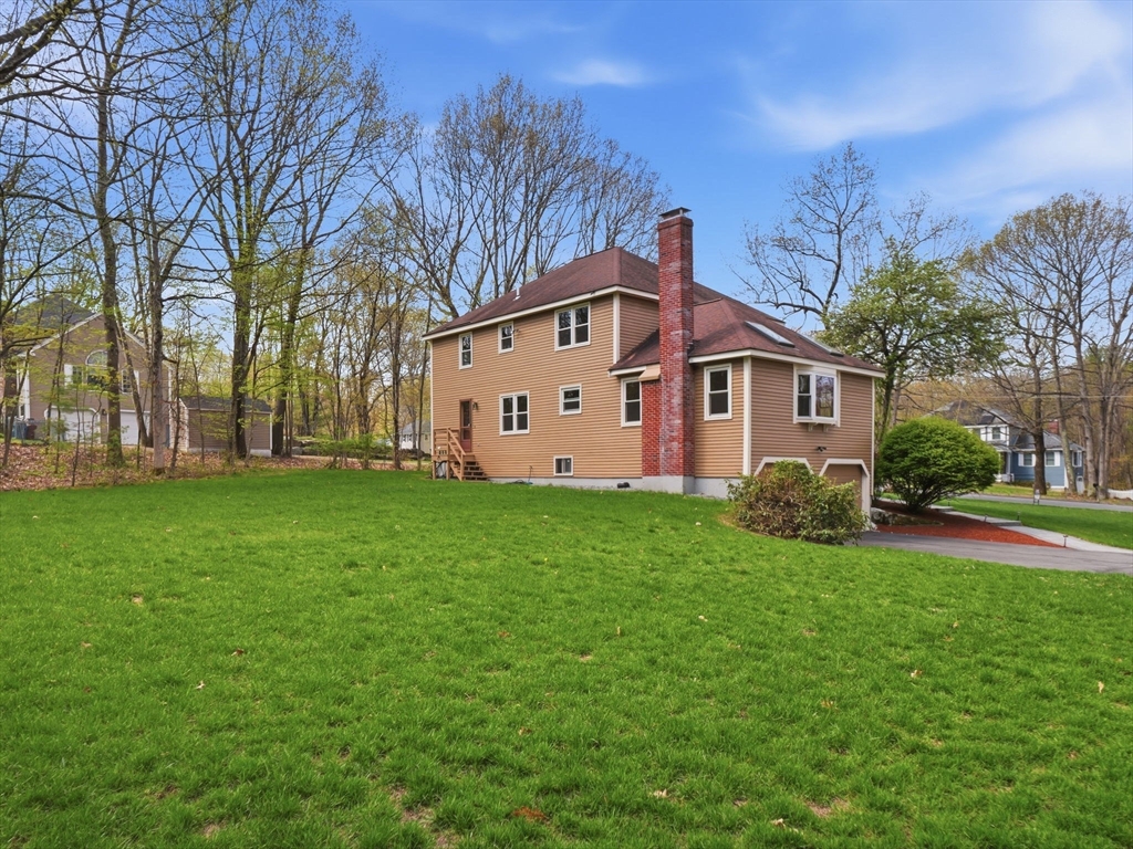 26 Nevada Road Tyngsborough, MA 01879 - Photo 39 of 42 a view of a yard in front of a house with plants and large trees