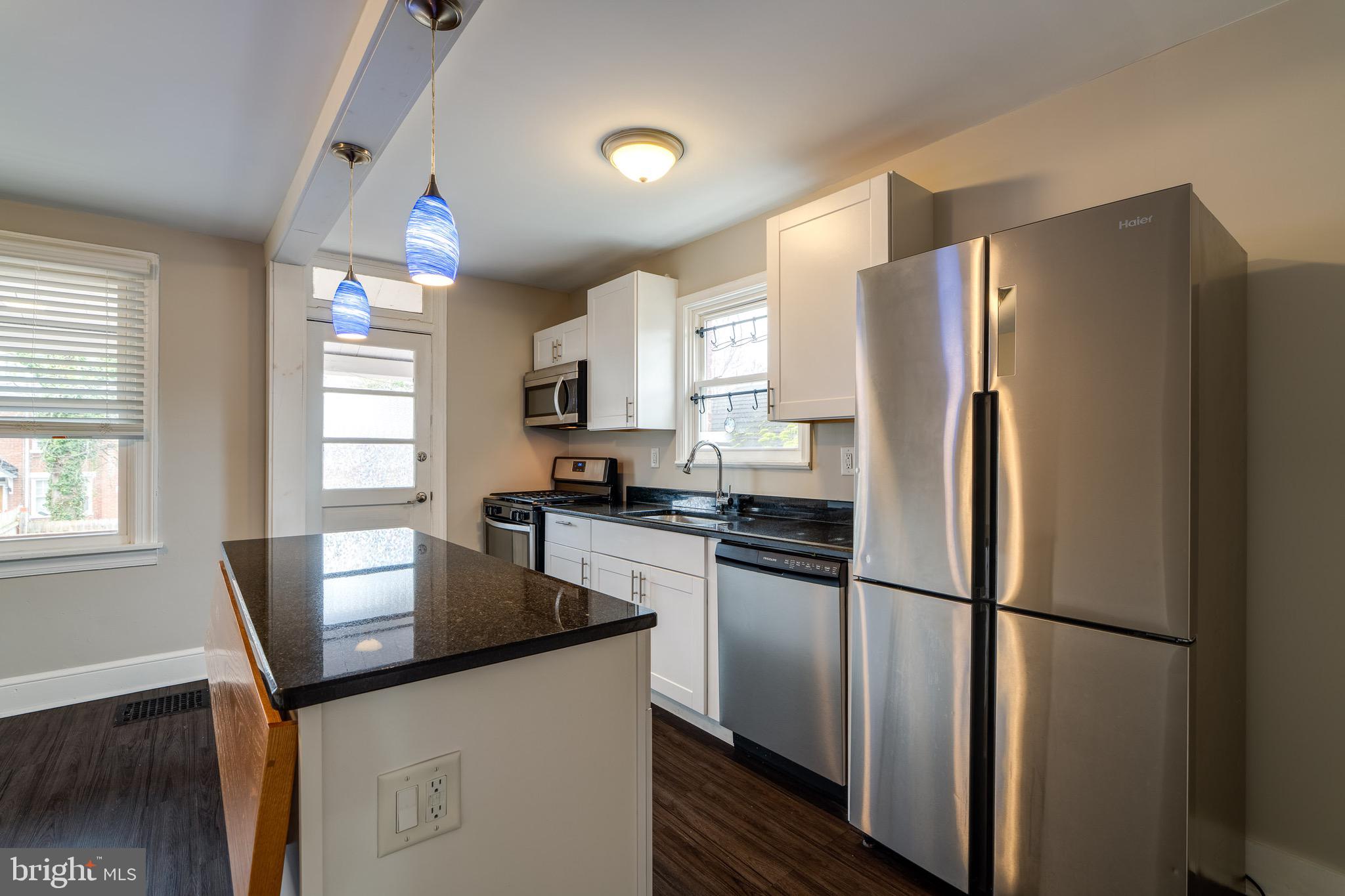 679 Poplar Street Lancaster, PA 17603 - Photo 13 of 32 a kitchen with stainless steel appliances a refrigerator a sink a stove a microwave a center island and cabinets