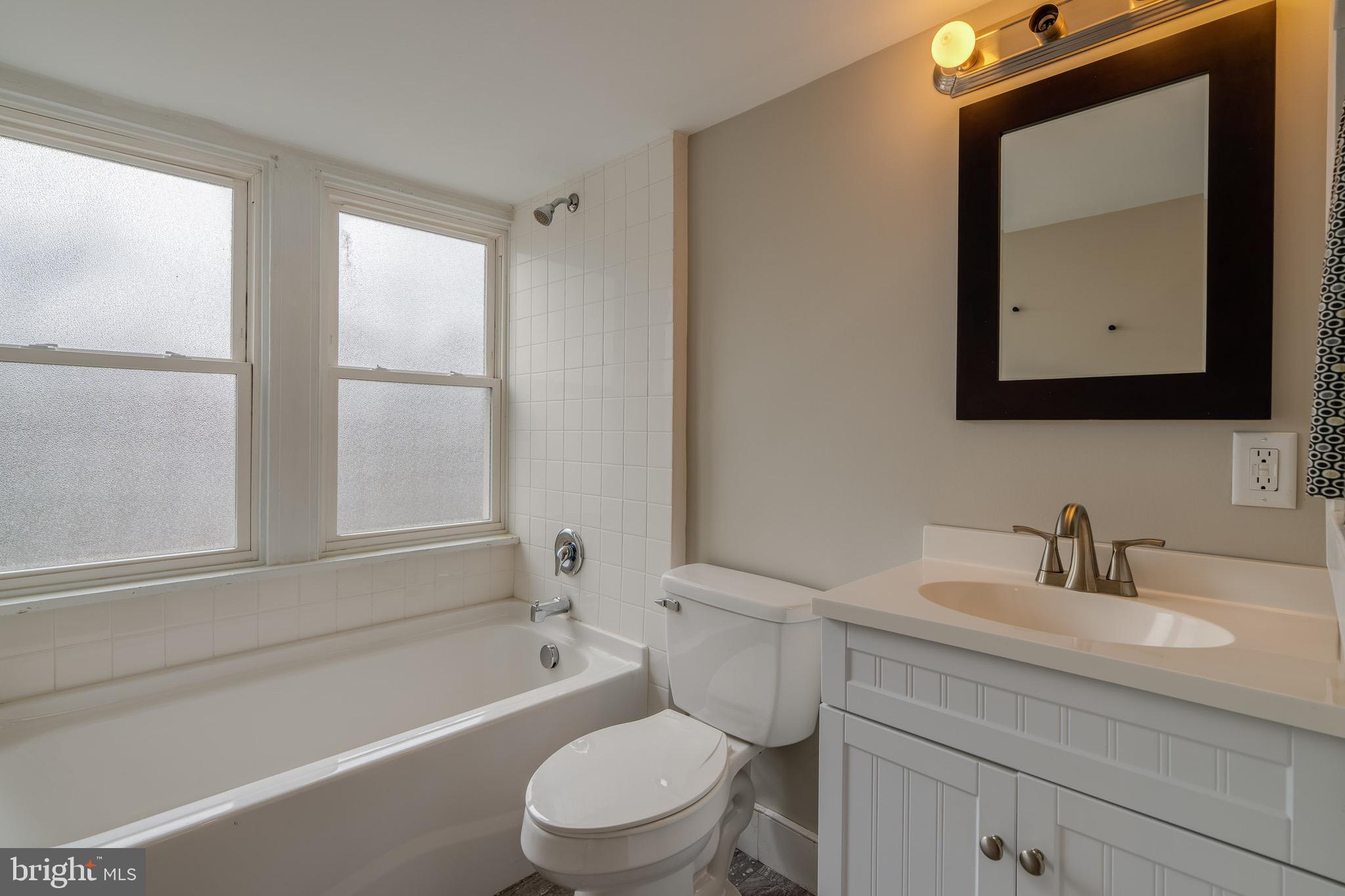 679 Poplar Street Lancaster, PA 17603 - Photo 25 of 32 a bathroom with a toilet a sink a tub and mirror
