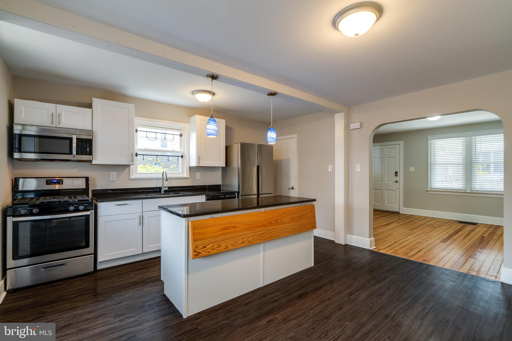 679 Poplar Street Lancaster, PA 17603 - Photo 10 of 32 a large kitchen with stainless steel appliances granite countertop a stove and a wooden floors