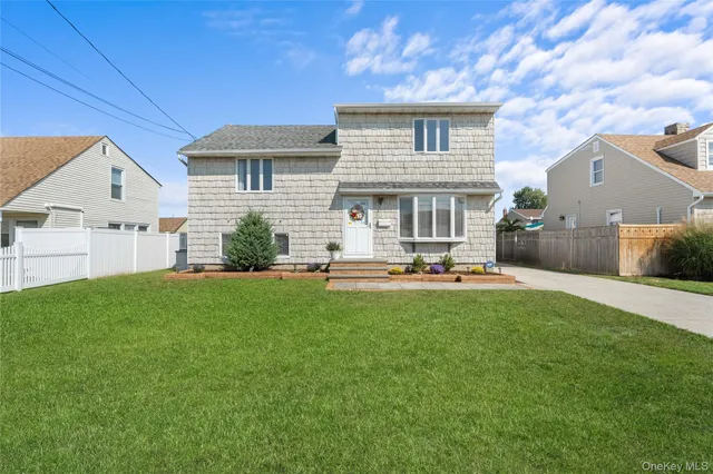 a view of a house with backyard and a tree